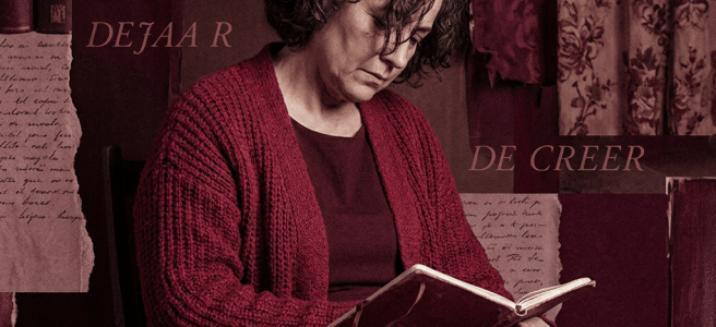 Woman in red cardigan reading a book, holding rosary beads